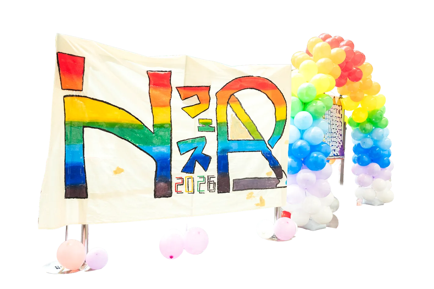 手作りの虹色の横断幕とバルーンアーチで彩られた文化祭会場の装飾