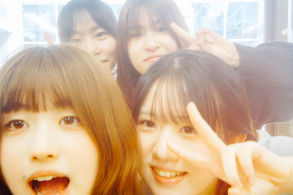 自撮りでピースサインをする学生たち